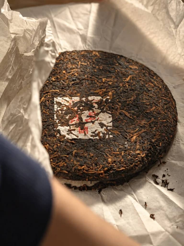 Compressed aged vintage Pu-erh tea cake in paper wrap